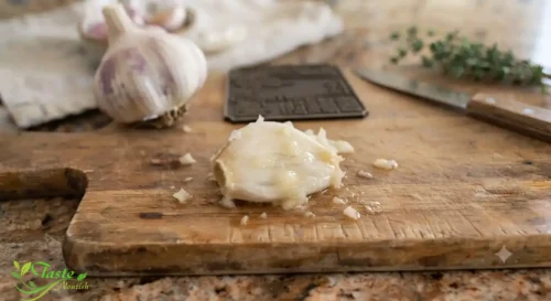Crushed raw garlic clove releasing allicin on a cutting board