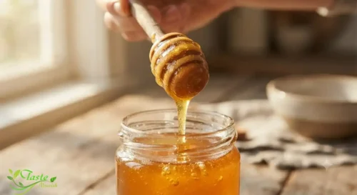 Honey vs Maple Syrup: Golden raw honey dripping from a wooden honey dipper