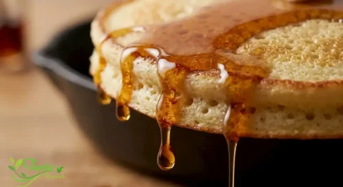 almond flour pancake with syrup dripping down the side