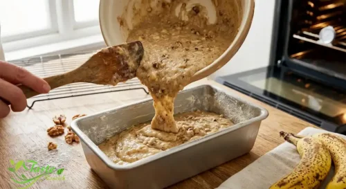 Banana bread batter poured into a greased loaf pan before baking