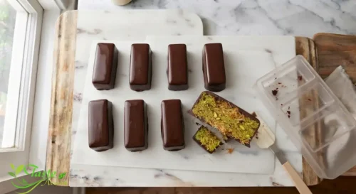 chocolate kunafa bar sliced open showing crunchy pistachio kataifi layer